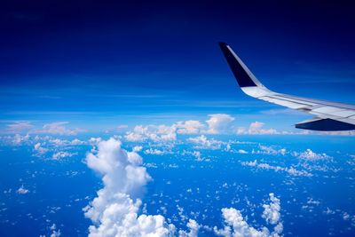 Aerial view of aircraft wing against blue sky
