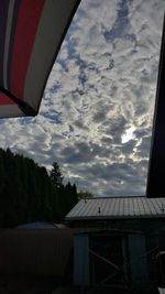 Airplane flying over building against sky