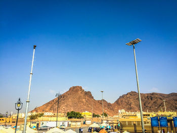 Street by mountains against clear blue sky