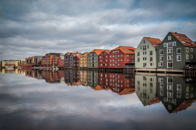 Reflection of houses in water against sky