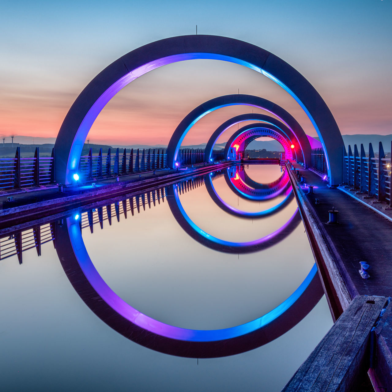 REFLECTION OF ILLUMINATED BRIDGE IN WATER