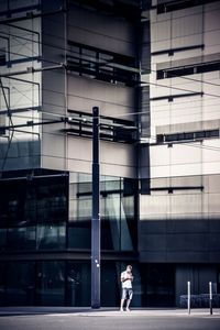 Full length of mature man standing against modern building in city