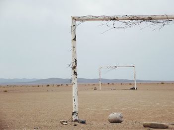 Damaged goal post on field against sky