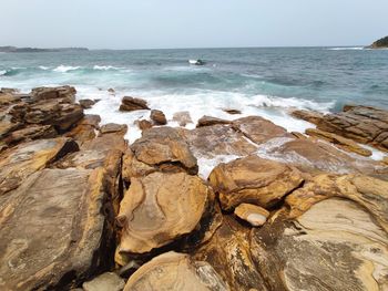 Rocks on beach against sky