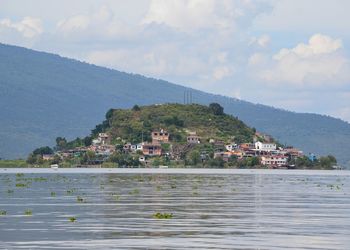 Scenic view of sea by buildings against sky