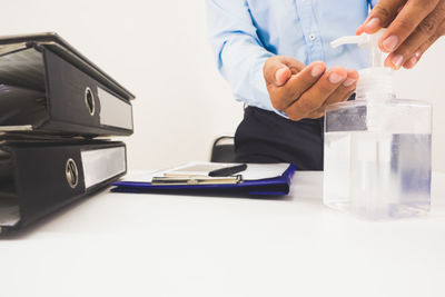 Midsection of man holding ice cream on table