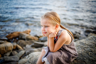 Young woman on rock at beach