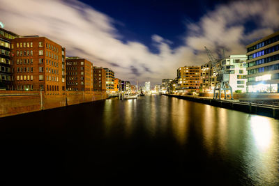 Buildings in city against cloudy sky