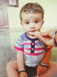 Portrait of cute baby girl sitting at home