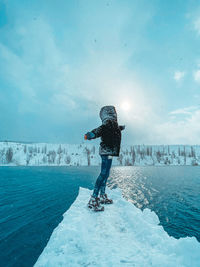 Man standing on snow against sky during winter