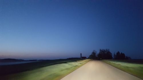 Road amidst landscape against clear blue sky