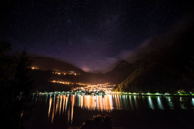 Scenic view of lake against mountains at night
