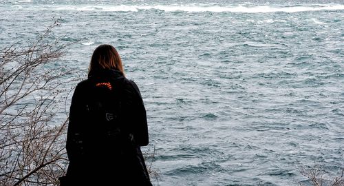 Rear view of woman standing in sea