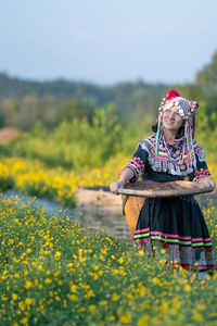 Woman with yellow flowers on field