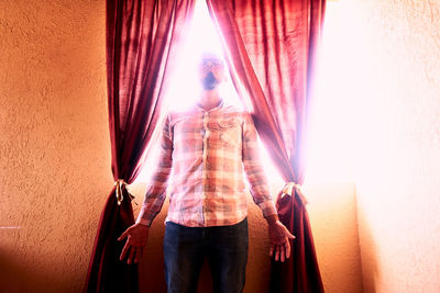 Man standing by window at home