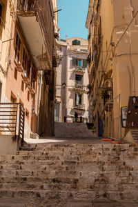 Low angle view of alley amidst buildings in city