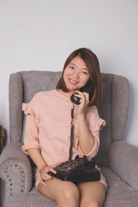 Portrait of a smiling young woman sitting on sofa