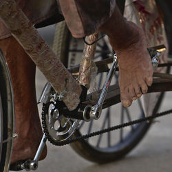 Low section of man working with bicycle