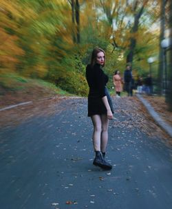 Full length portrait of young woman on road