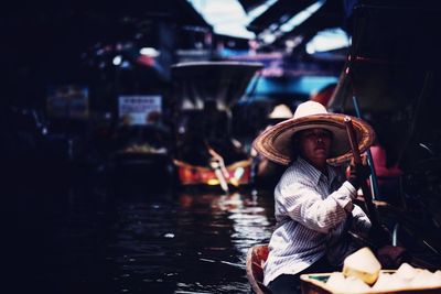 Woman sitting in boat at market