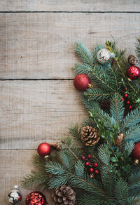 Christmas greenery and decorations against a rustic wood backdrop.