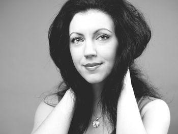 Portrait of woman smiling against gray background