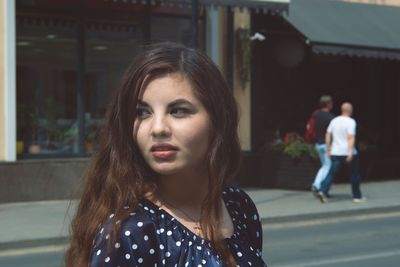 Thoughtful young woman in city