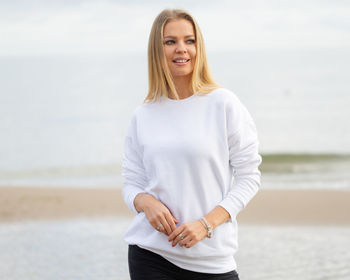 Beautiful young woman standing on beach