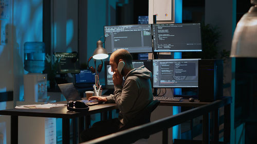 Rear view of woman sitting on table