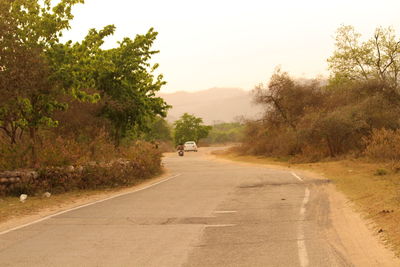 Road in countryside landscape against clear sky