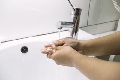 Close-up of hands working in bathroom