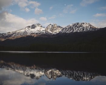 Scenic view of lake and snowcapped mountains against sky