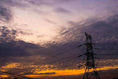 Low angle view of silhouette electricity pylon against sky during sunset