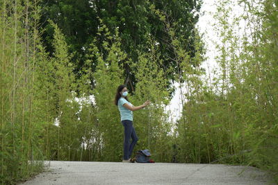 Side view of woman standing by plants