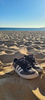 High angle view of shoes on beach against clear sky