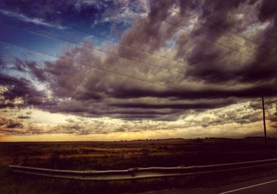 Scenic view of field against cloudy sky