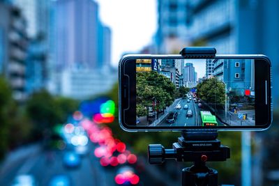 Close-up of camera phone on road in city