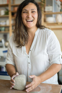 Woman kneading clay to make pottery