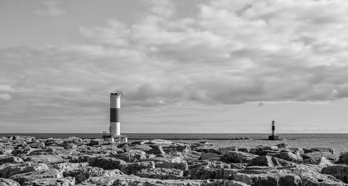 Lighthouse by sea against sky
