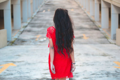 Rear view of young woman walking on bridge