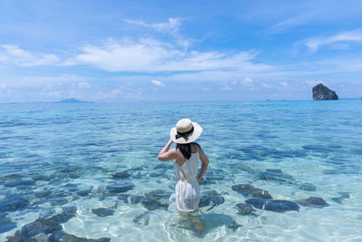 Woman in sea against sky