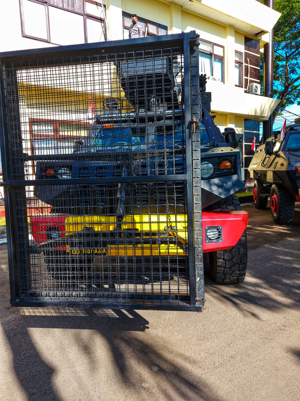 sunlight, architecture, transportation, shadow, day, city, vehicle, built structure, mode of transportation, urban area, nature, building exterior, outdoors, no people, metal, street, car, land vehicle, fence