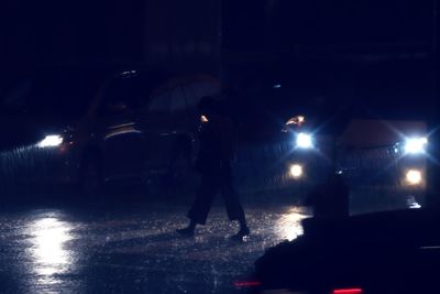 Man standing in car at night