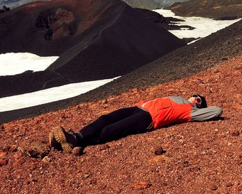 High angle view of young woman lying on mountain