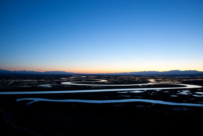 Scenic view of landscape against clear sky at sunset