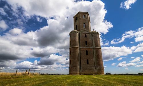 Rural landscape against cloudy sky