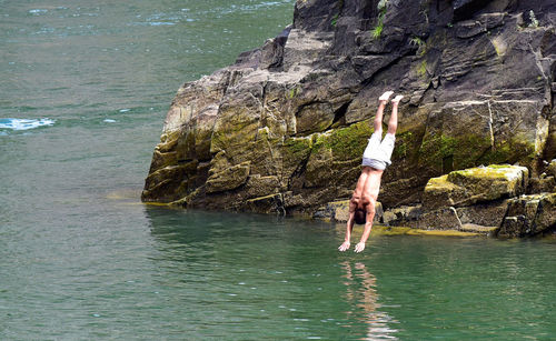 Man standing on rock by sea