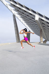 Athletic mixed race woman in action running through the city