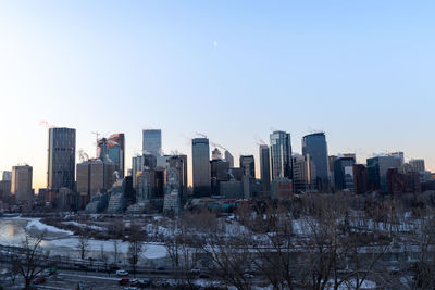 Buildings in city against clear sky during winter