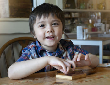 Portrait of cute boy sitting at table